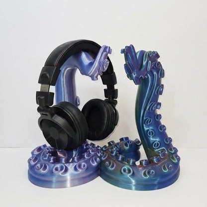 Black headphones on a blue and purple stand against a white background
